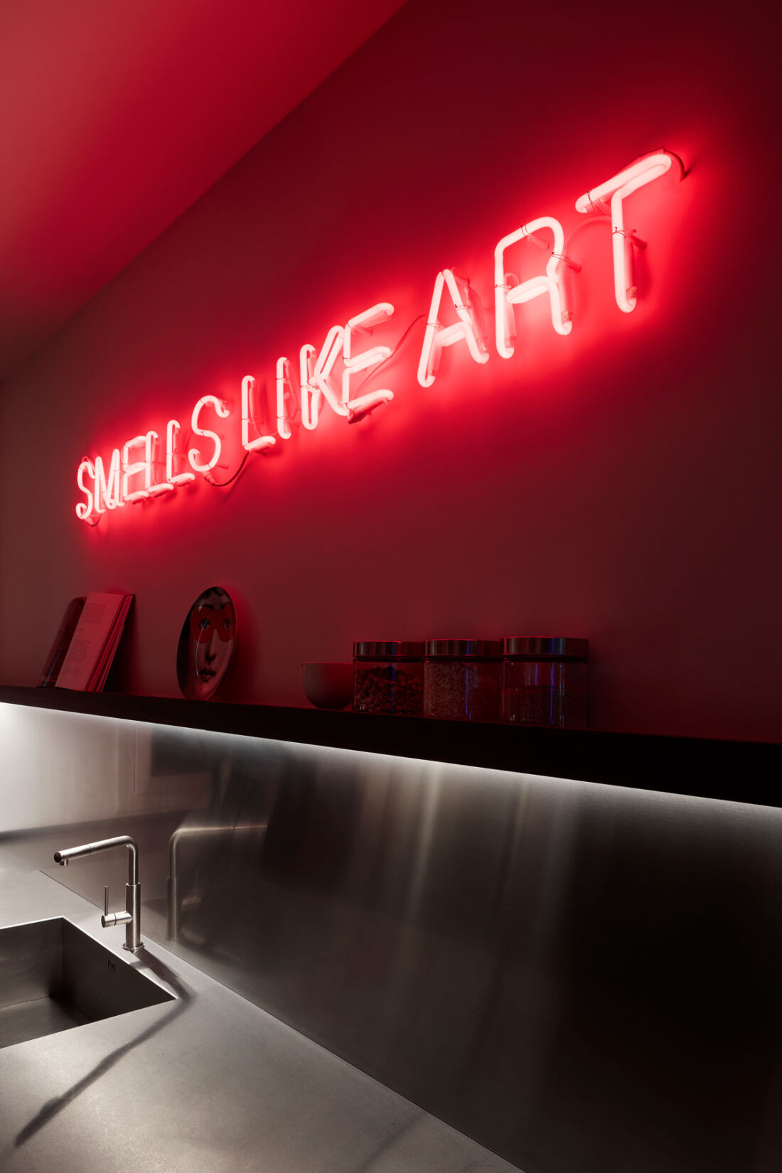 artistic red neon over a stainless steel kitchen top with accessories