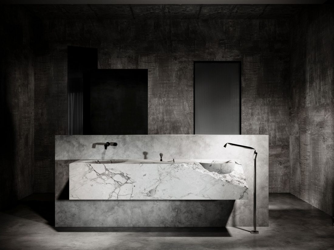 modern industrial bathroom with marble washbasin and artistic faucets by night